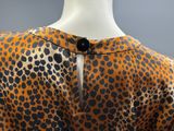 a close up of a mannequin wearing a leopard print dress