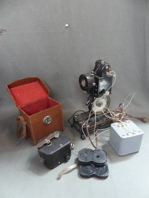 une petite boîte contenant un appareil photo et d'autres objets, posée sur la table