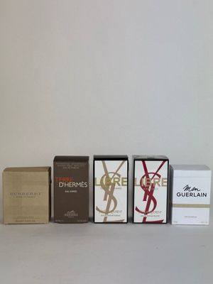 three boxes of perfume sitting next to each other on a white surface