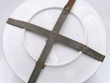 a white plate with a cross on it on a stand