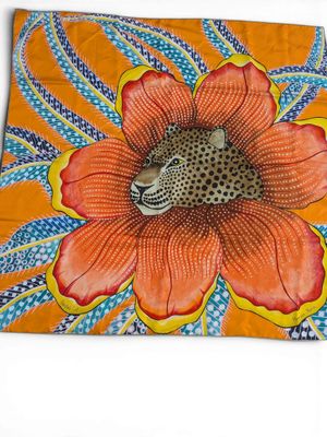 leopard in a flower on an orange background with blue and yellow leaves