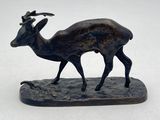 statue of a deer on a rock on a white surface