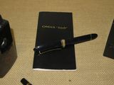 a pen and a notebook on a table next to a camera