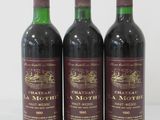 three bottles of red wine sitting next to each other on a white surface