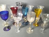 many different colored glass goblets and wine glasses on the table