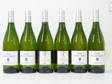 six bouteilles de vin blanc alignées sur une table