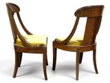 two wooden chairs with yellow upholstered cushions on them