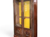 une vieille armoire en bois avec des portes vitrées et une porte jaune