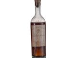 une vieille bouteille de whisky posée sur une surface blanche