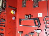 a red wall with a bunch of tools hanging on it
