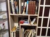 a book shelf with many books on it in a room