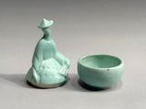 a small vase and a small bowl sitting next to each other