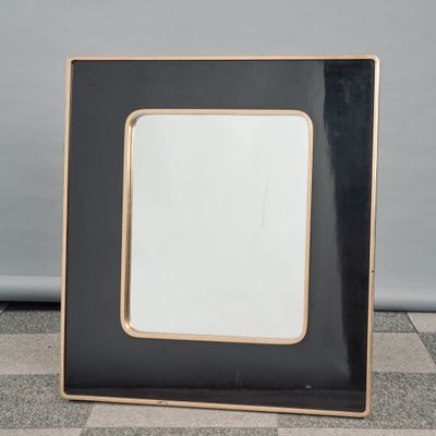 an image of a black and gold picture frame on a checkered floor