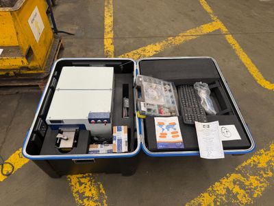 a suitcase with a computer inside of it sitting on the ground