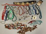 many necklaces and bracelets laid out on a table
