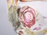a close up of a vase with a flower on it