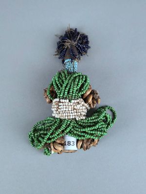 broche en perles représentant une femme en robe verte