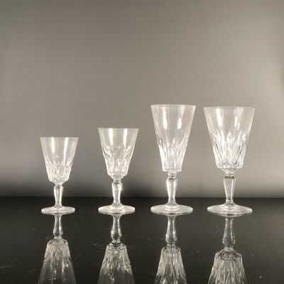 four empty wine glasses are lined up on a black table
