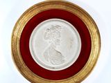 an image of a gold and white medallion with a woman ' s face