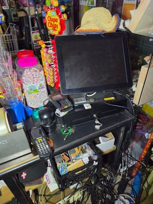 a desk with a laptop and a television on top of it