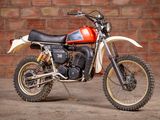 a red and white dirt bike parked in front of a brick wall