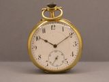 une montre de poche en or posée sur une table
