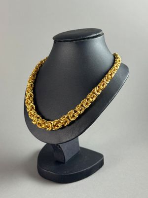 a close up of a mannequin with a gold chain on it
