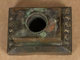 a small square metal object with a hole in it