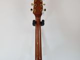 a close up of a guitar on a stand against a white wall