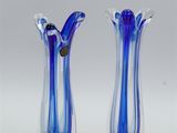 pair of blue and white glass vases sitting on top of a table