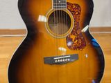 an acoustic guitar sitting on top of a hard wood floor next to a wall