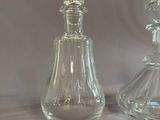 pair of clear glass perfume bottles sitting on top of a white table