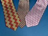 three different colored ties on a blue surface with a blue background
