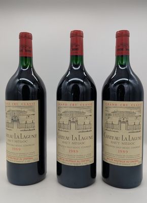 trois bouteilles de vin rouge posées sur une table blanche