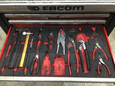 de nombreux outils différents dans une boîte à outils posée par terre