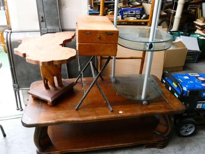 une table avec un plateau en verre et une table en bois sur laquelle est posé un éléphant en bois