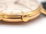 a close up of a gold watch with a black strap