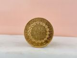 a close up of a gold coin sitting on top of a marble counter