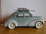 une petite voiture sur laquelle est posée une planche de surf