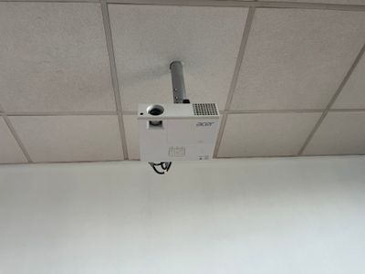 a small projector hanging from the ceiling in a room