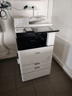 a white printer sitting on top of a white cabinet