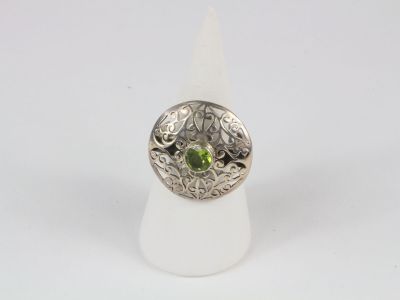 a close up of a ring with a green stone in it