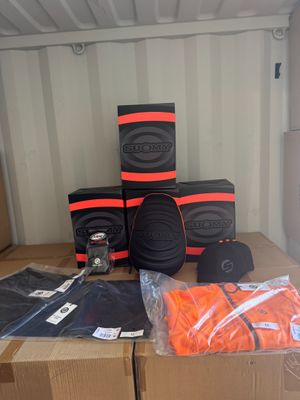 plusieurs cartons contenant des objets orange et noirs posés sur une table