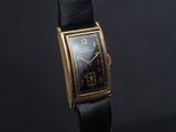 gros plan d'une montre sur une surface noire avec un fond noir