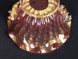 a red and gold vase on a black surface