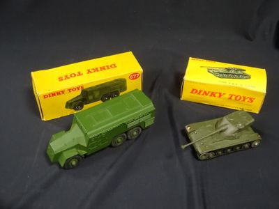 two toy army vehicles are sitting next to each other on a black surface