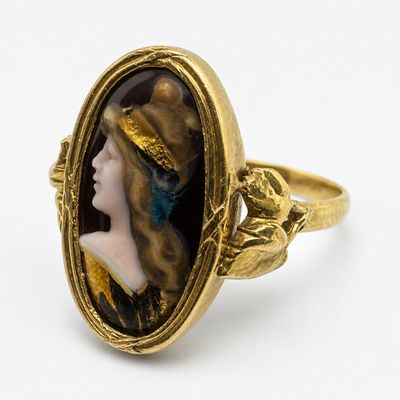 une image représentant une bague en or sur laquelle figure le portrait d'une femme portant un chapeau