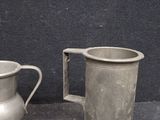 two silver mugs sitting next to each other on a table