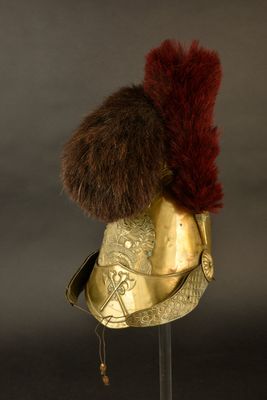 casque orné de fourrure sur un support, devant un fond noir