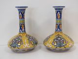 pair of yellow and blue vases sitting on a white surface